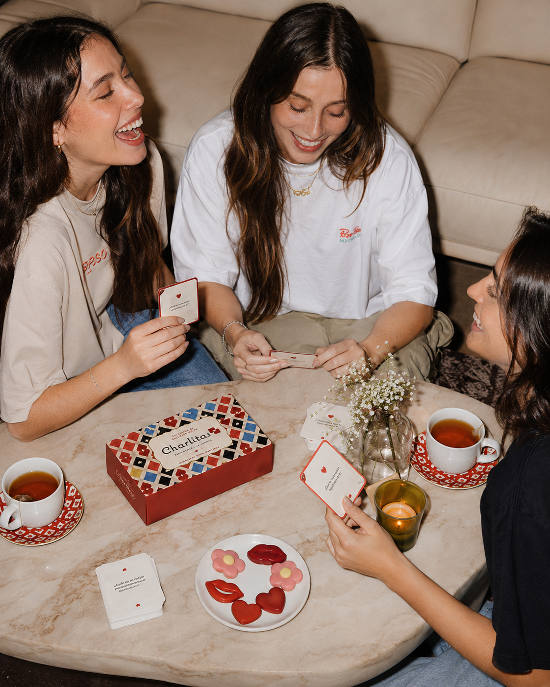Amigas compartiendo las tarjetas, galletas y té de Charlitas