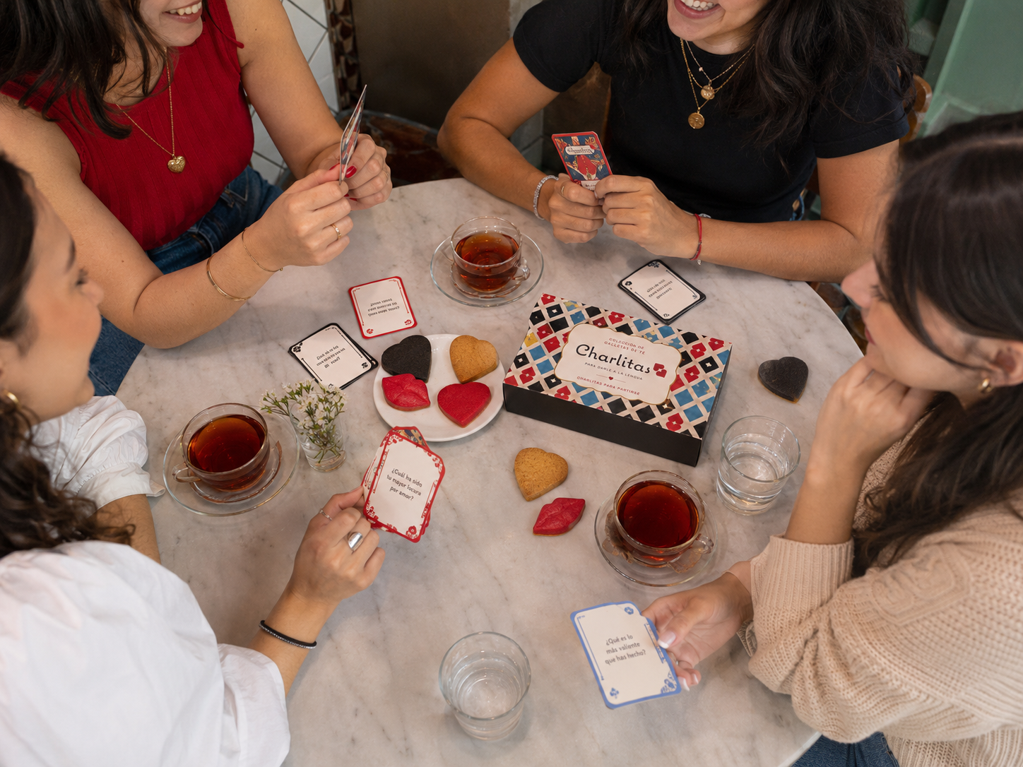 Encuentro Charlitas alrededor de una mesa con tarjetas, té y galletas
